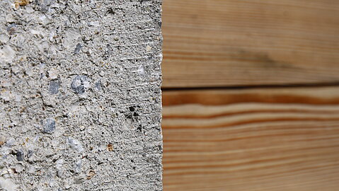 Detailaufnahme der Fassade, die aus Holz und Beton besteht. 