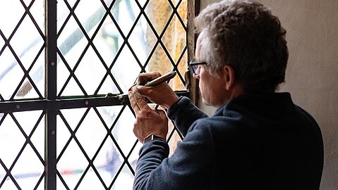 Die Kunstglaser bessern die Glasscheiben mit Spezialkitt aus. 