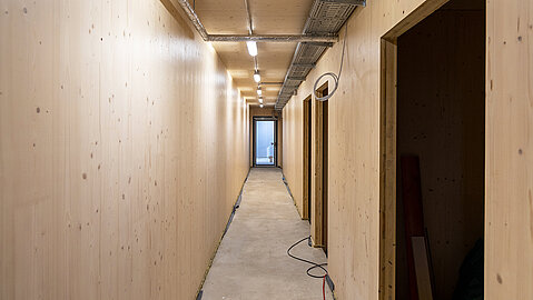 Blick in einen Flur, von dem Zimmer abgehen: Alles wurde aus Holz gebaut
