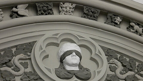 Eine der Wände schmückt der Kopf der Göttin der Gerechtigkeit, Justizia.