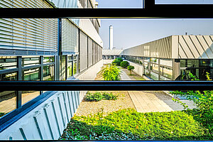 Die grünen Bereiche stehen im Kontrast zur Betonfassade des Gebäudes.