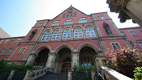 Zum Eingang des Land- und Amtsgerichts Aachen geht es über eine Treppe. Das Gebäude besteht aus rotem Backstein.