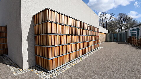 Bücherregale wurden aus Sibirischer Lärche und in Form von Holzelementen draußen vor dem Gebäude nachgestellt. 