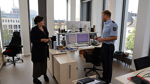 Ein uniformierter Polizist vom Polizeipräsidium Düsseldorf beschreibt BLB NRW Geschäftsführerin Gabriele Willems seine verbesserte Arbeitssituation nach der Fertigstellung des ersten Bauabschnitts.