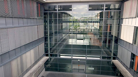 Zwei große Glasfronten zu beiden Seiten ermöglichen den freien Blick in das Foyer der TH Köln auf dem Campus Gummersbach. Man blickt mitten hindurch.