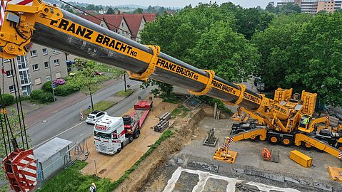 Aufnahme eines Krans bei der Arbeit auf dem Baufeld des Technikgebäudes.